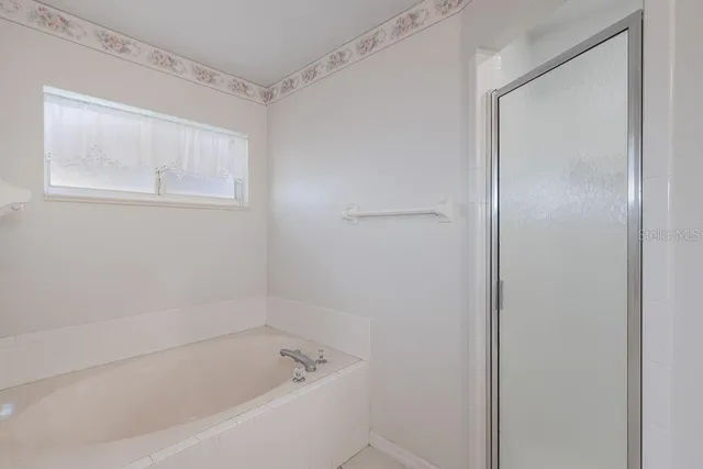 a white bath tub sitting next to a shower