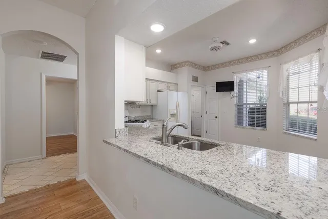 a kitchen with granite countertop a sink and a refrigerator