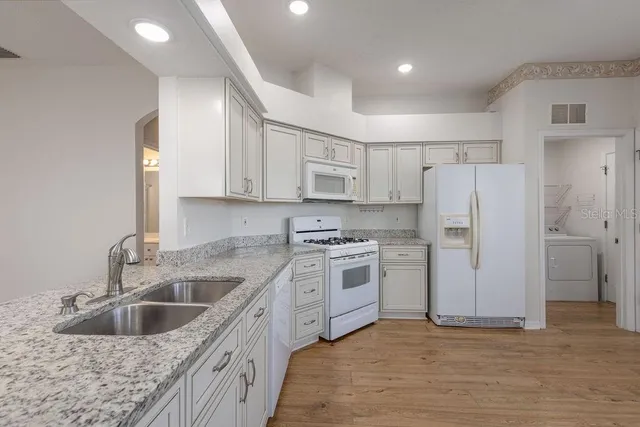 a kitchen with a sink cabinets and refrigerator