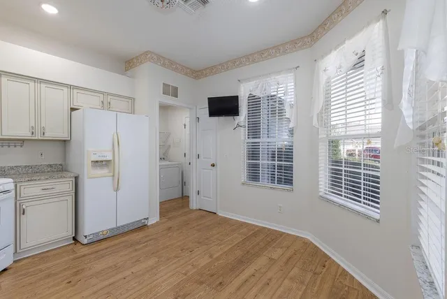 a kitchen with a refrigerator a stove top oven and large window