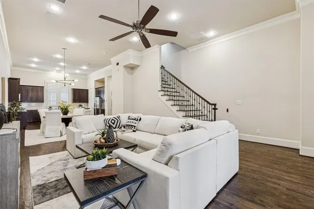 a living room with furniture kitchen view and a wooden floor