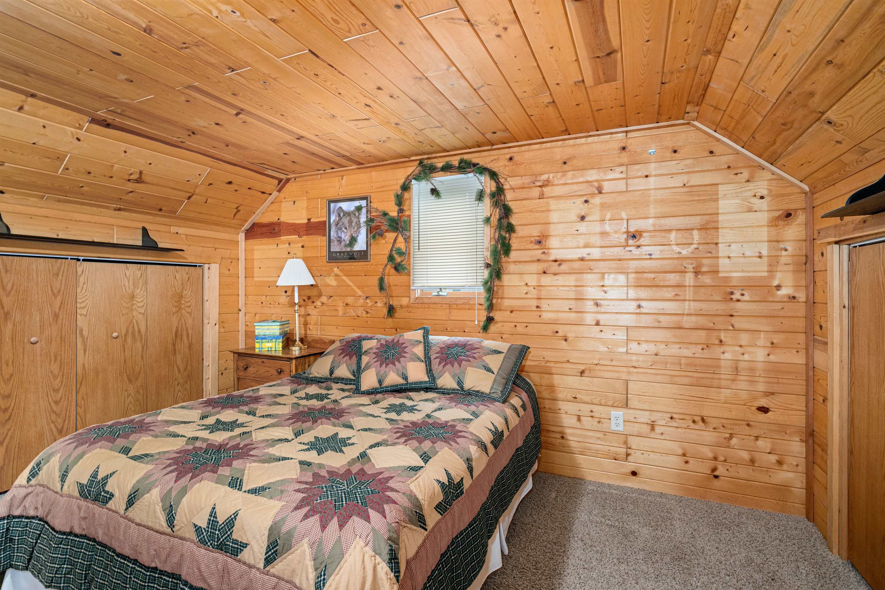 1207 Christianson Lake Road Two Harbors, MN 55616 - Photo 11 of 36 Bedroom featuring wood ceiling, lofted ceiling, wooden walls, and carpet