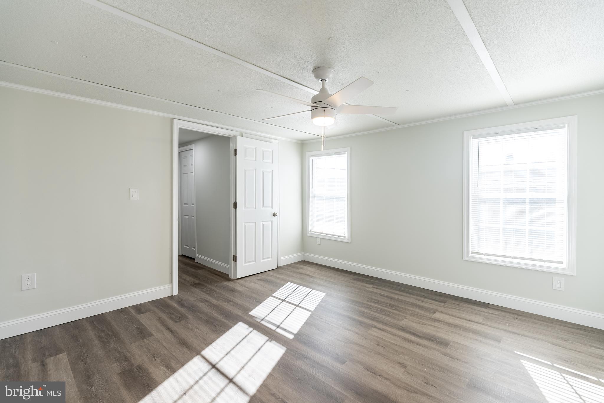 115 5th Street, Unit 40 Delaware City, DE 19706 - Photo 5 of 12 a view of empty room with wooden floor and fan