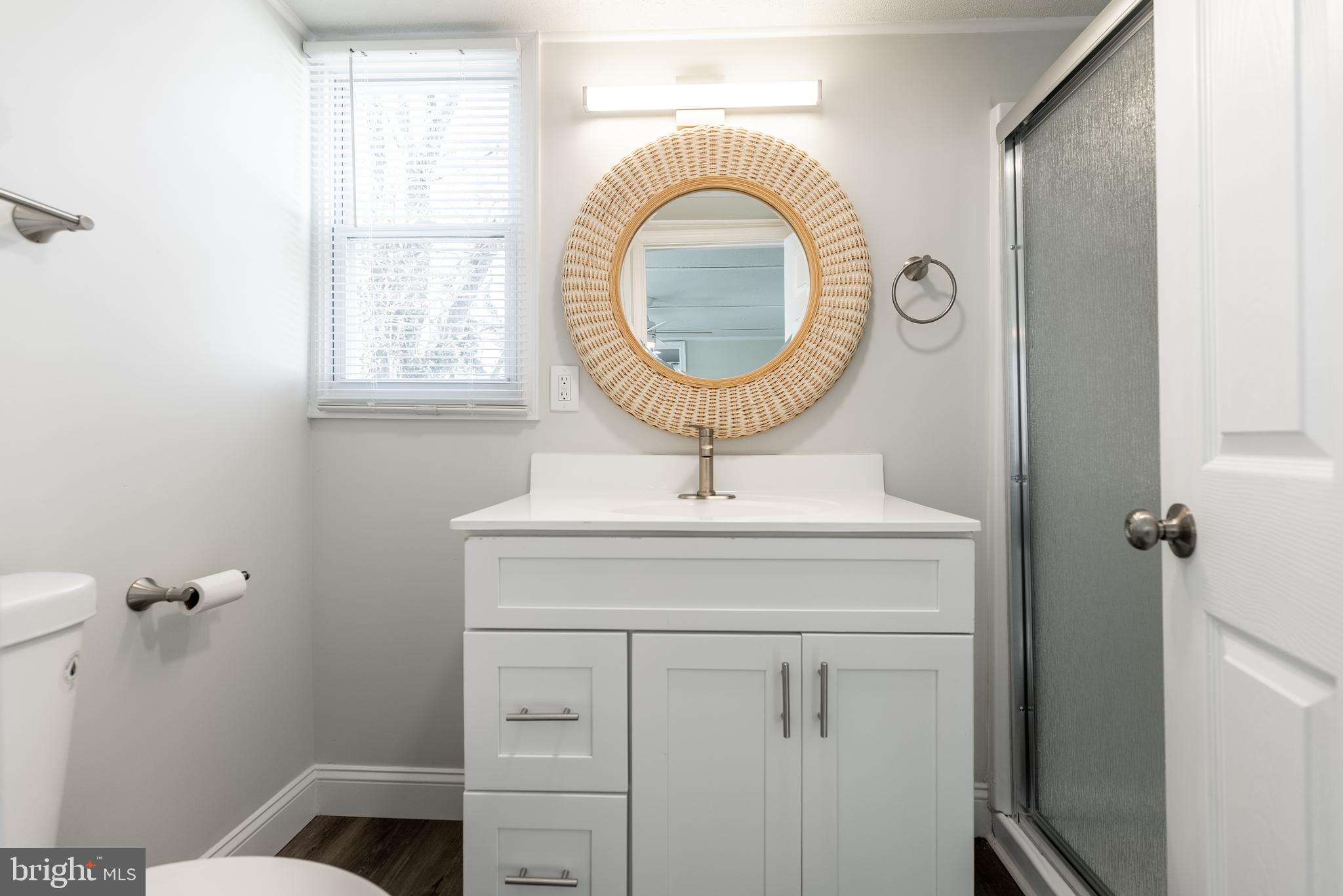 115 5th Street, Unit 40 Delaware City, DE 19706 - Photo 6 of 12 a bathroom with a sink a mirror and a toilet