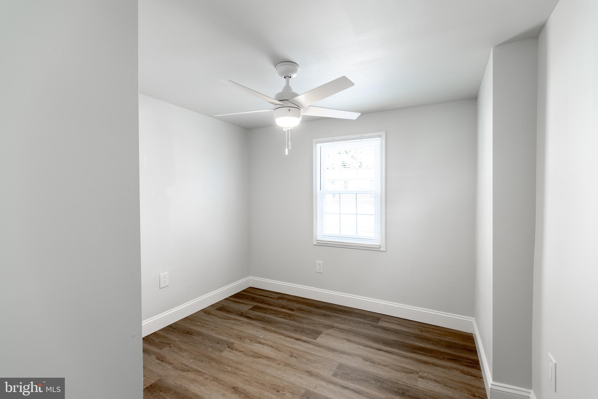 115 5th Street, Unit 40 Delaware City, DE 19706 - Photo 7 of 12 an empty room with wooden floor and windows