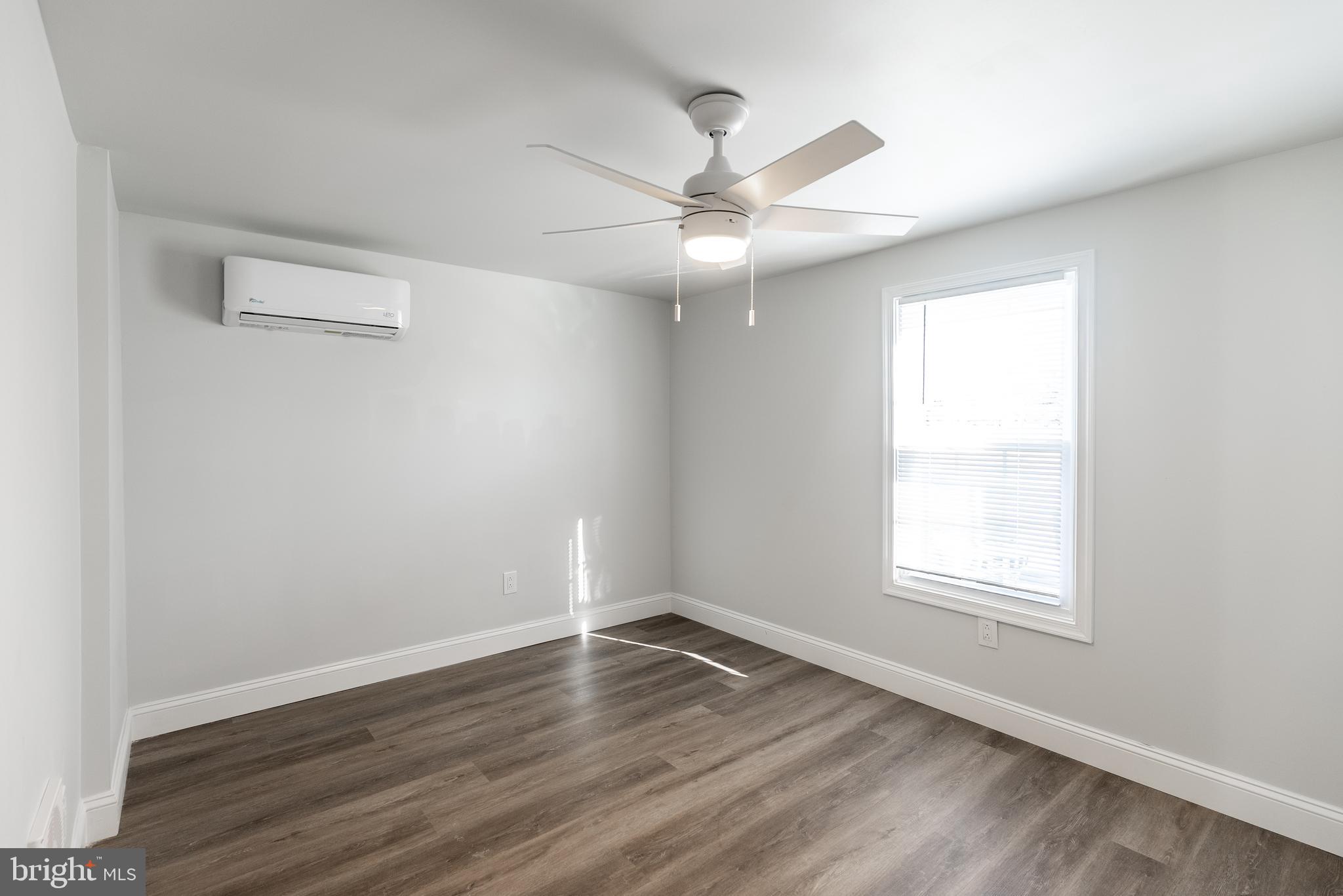 115 5th Street, Unit 40 Delaware City, DE 19706 - Photo 10 of 12 an empty room with wooden floor windows and fan