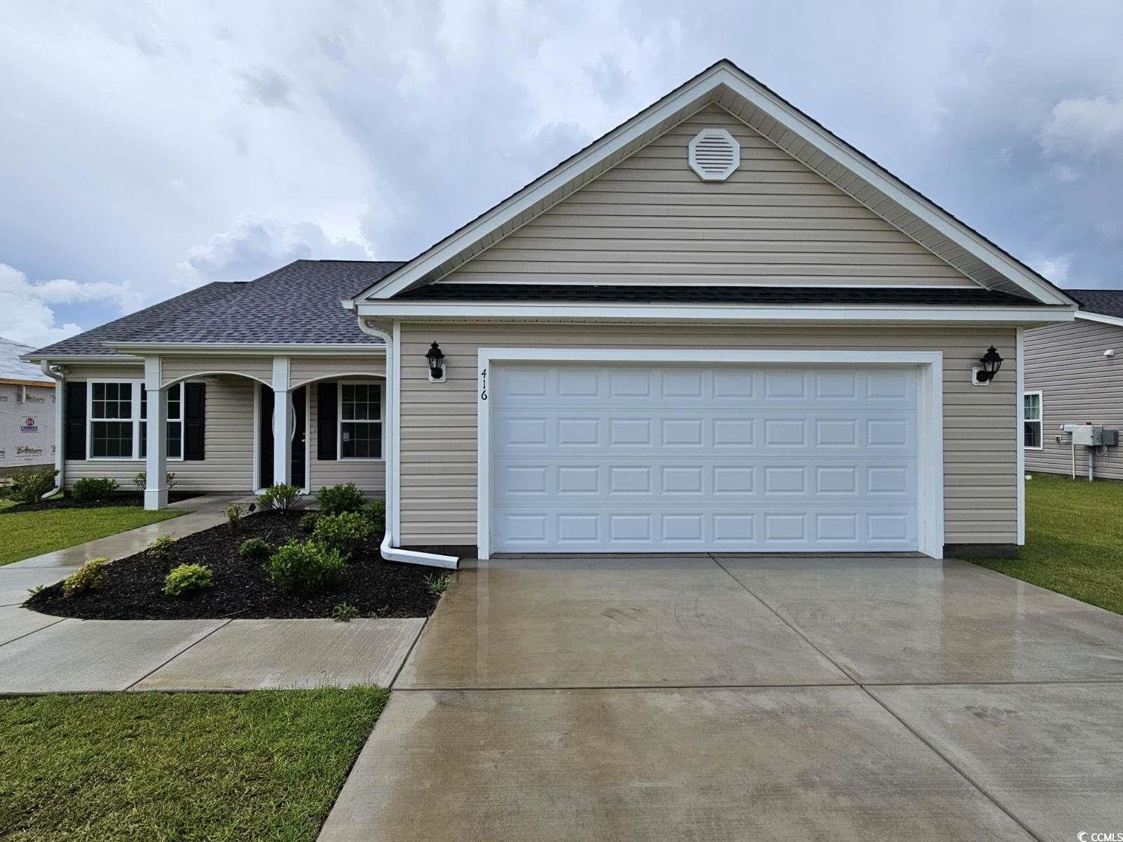 Ranch-style home featuring a garage and a front ya