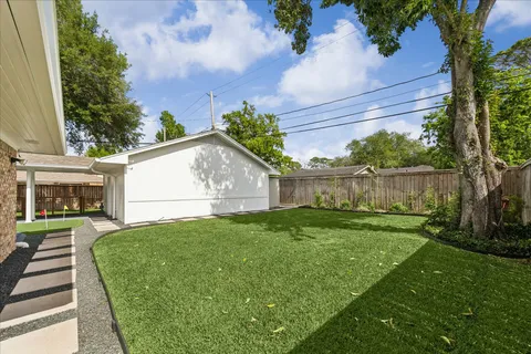 a view of a house with backyard sitting area and garden