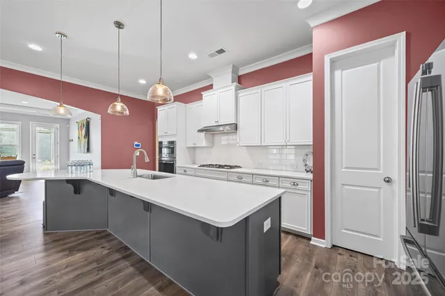 a kitchen with stainless steel appliances granite countertop a stove and a sink