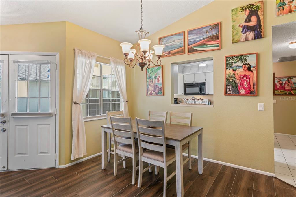 4740 Carrington Court New Port Richey, FL 34655 - Photo 21 of 66 a view of a dining room with furniture and a chandelier