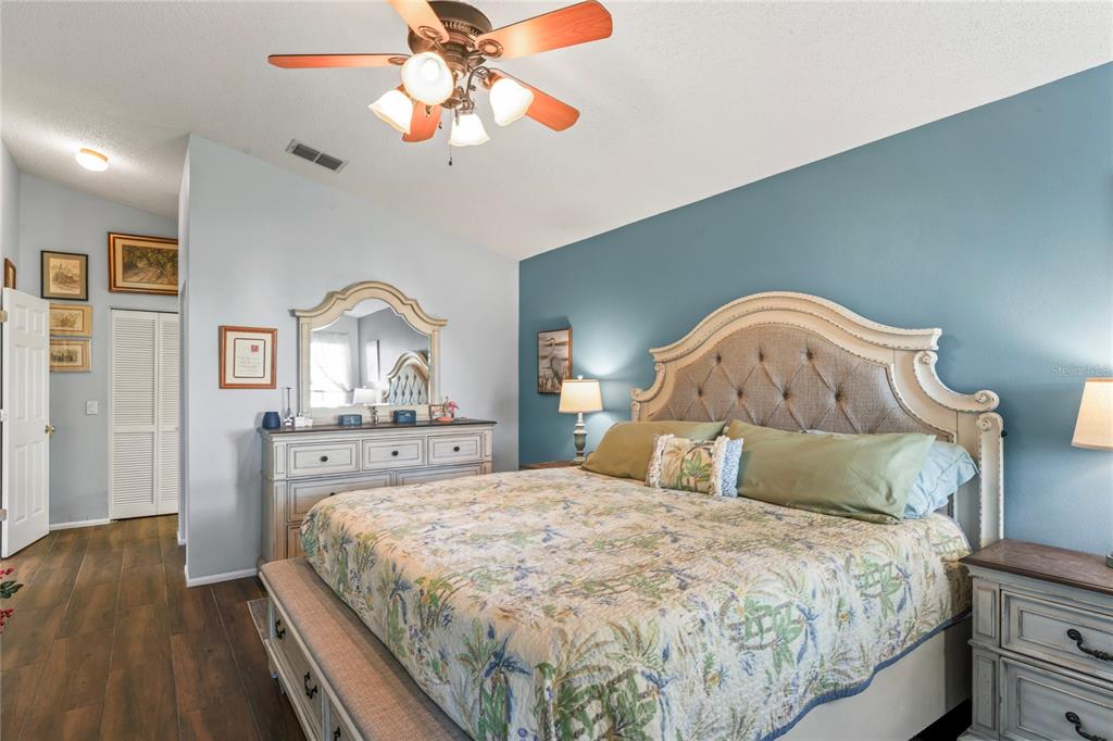 4740 Carrington Court New Port Richey, FL 34655 - Photo 32 of 66 a bedroom with a large bed and a chandelier