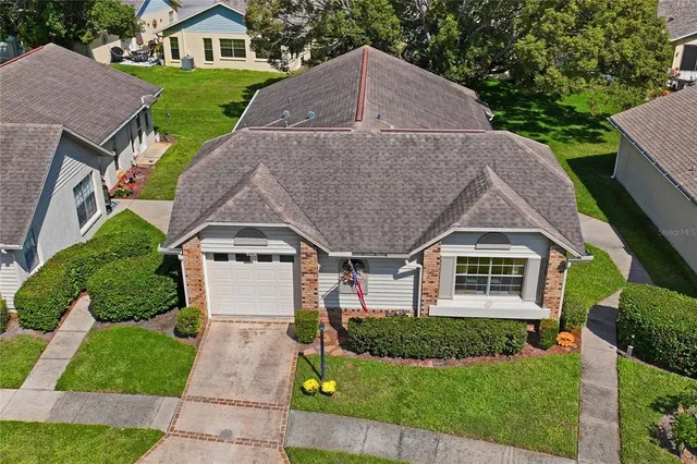 a view of a house with a big yard and large trees