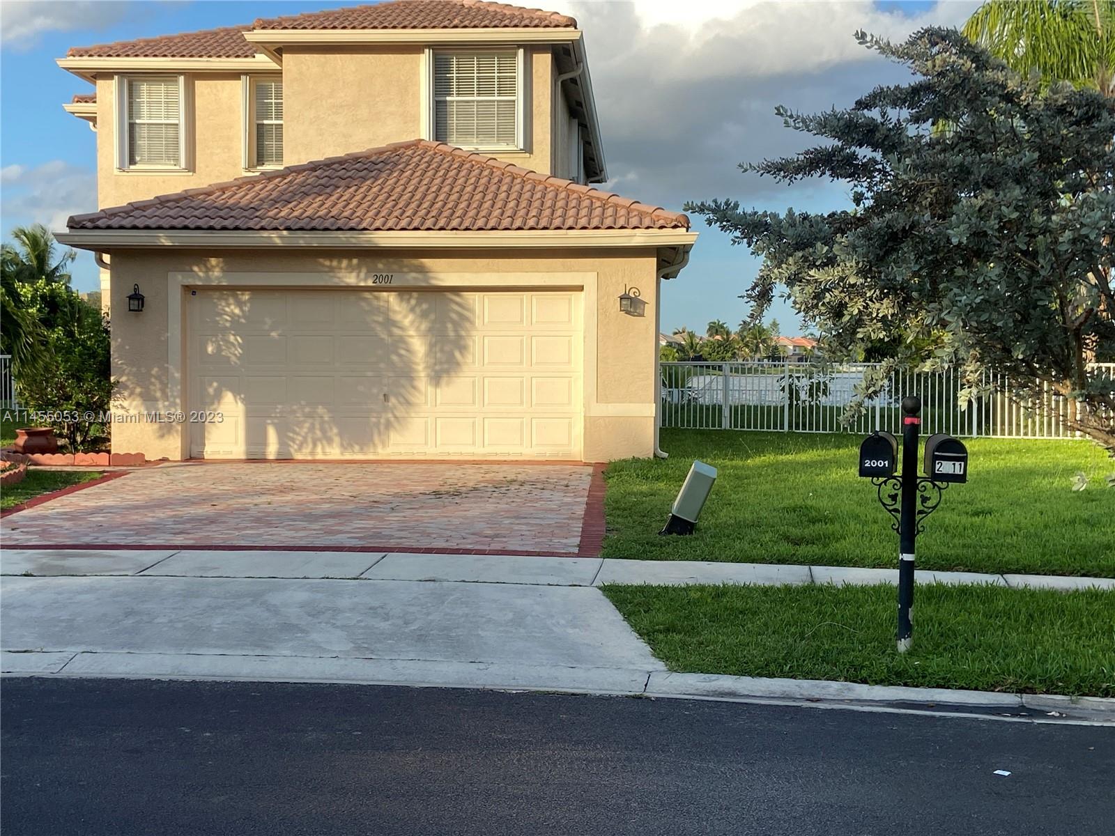 2001 Southwest 157th Avenue Miramar, FL 33027 - Photo 1 of 20 a front view of a house with a yard and garage