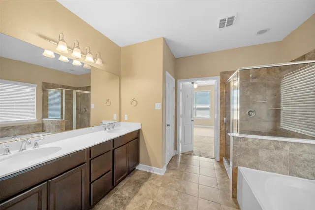 a spacious bathroom with a double vanity sink mirror and shower