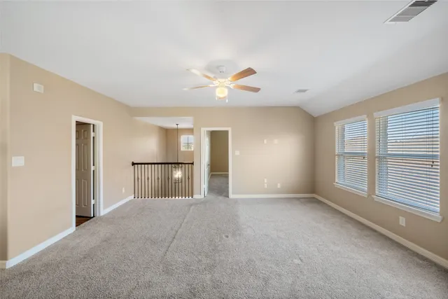 a view of empty room with a ceiling fan and window