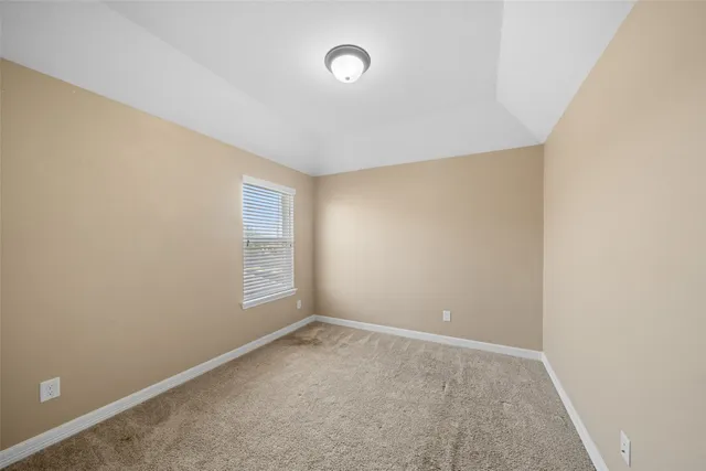 a view of an empty room with window and closet area