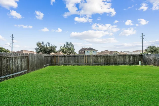 a view of a yard with a fence and trees