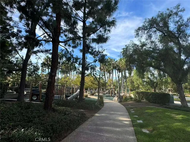a view of a playground with lots of green space and slide