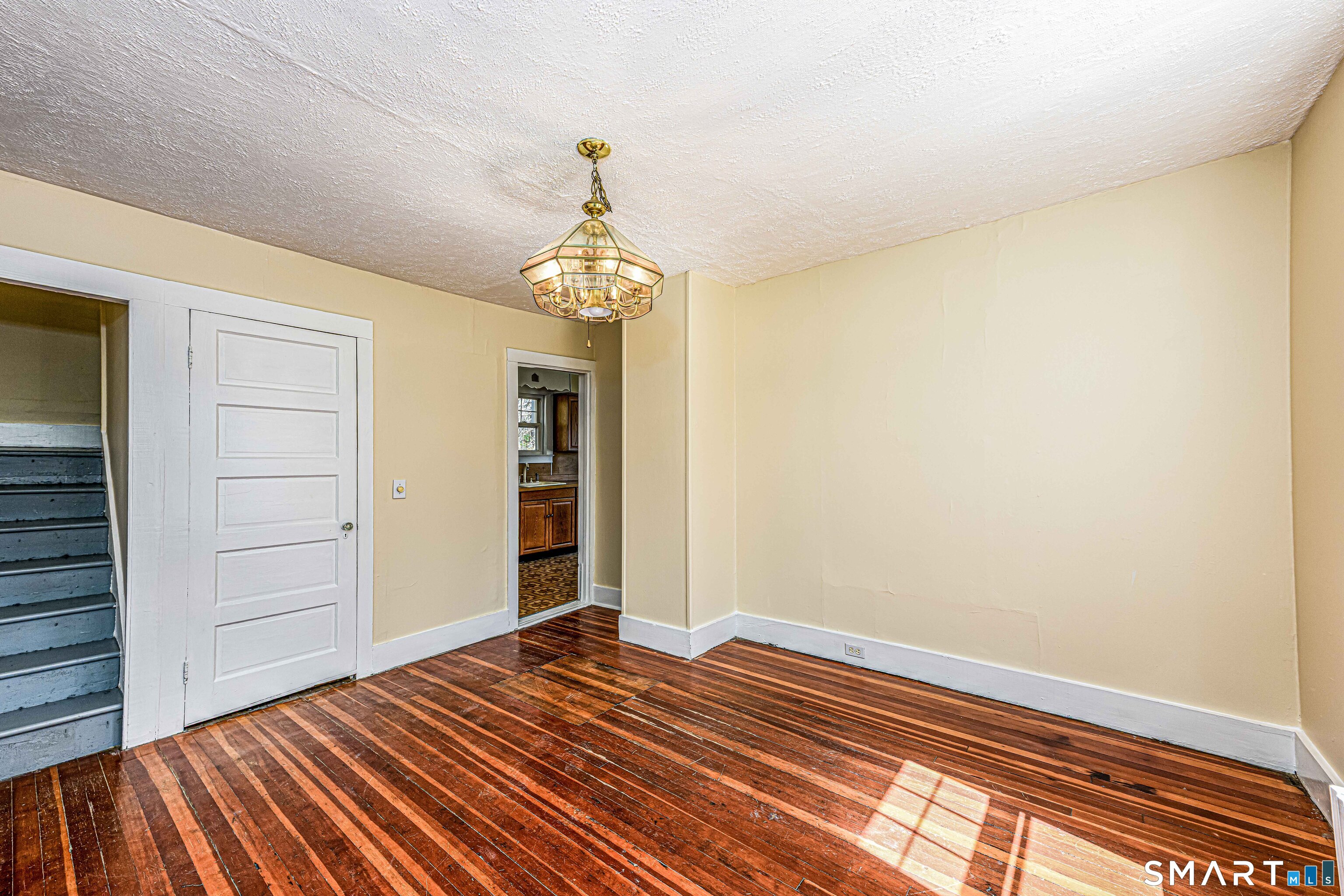 45 Rimmon Road North Haven, CT 06473 - Photo 13 of 40 Scissor stairs in the left side of this photo lead to the second floor, white door leads to the basement.