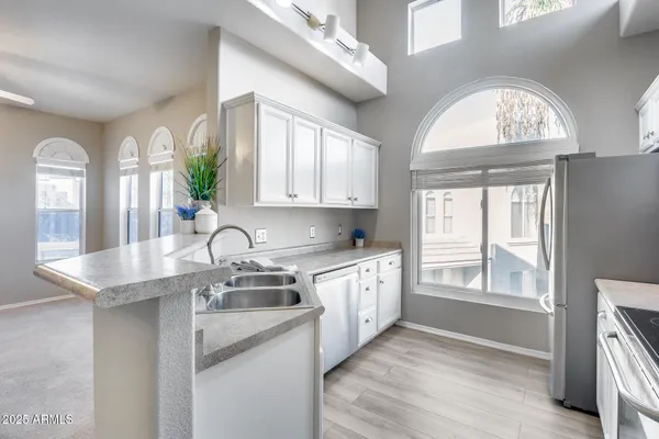 a kitchen with stainless steel appliances a sink a window and cabinets