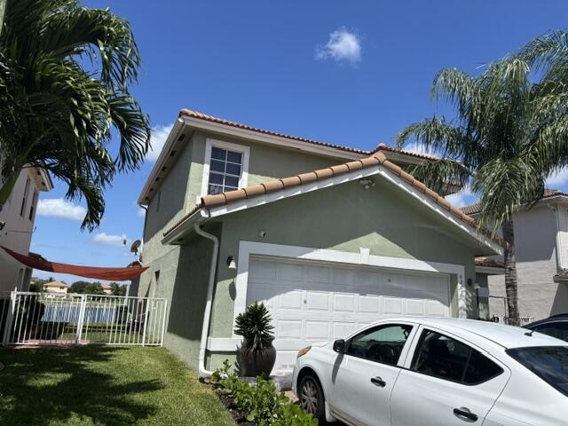 6207 Adriatic Way West Palm Beach, FL 33413 - Photo 2 of 26 a front view of a house with garage