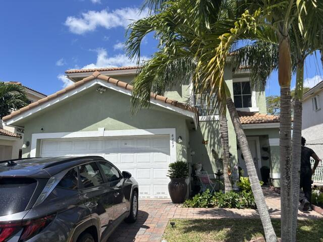 6207 Adriatic Way West Palm Beach, FL 33413 - Photo 3 of 26 a car parked in front of white house