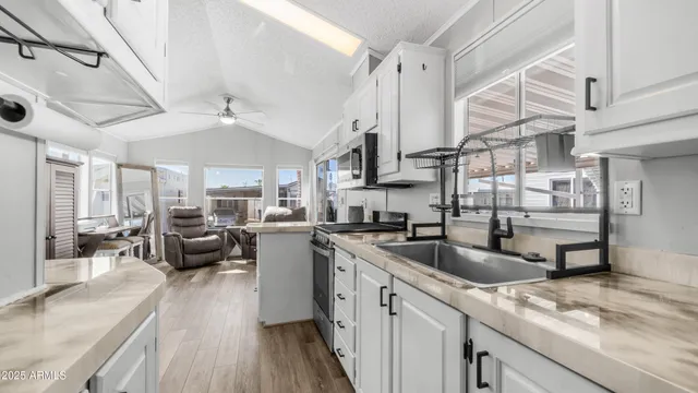 a kitchen with counter top space a sink cabinets and appliances