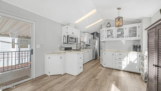 a kitchen with white cabinets and wooden floors