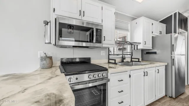 a kitchen with appliances a sink and cabinets