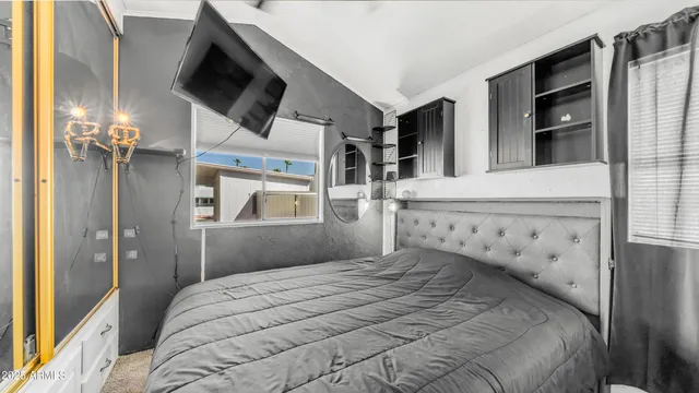 a bedroom with a bed and a flat screen tv