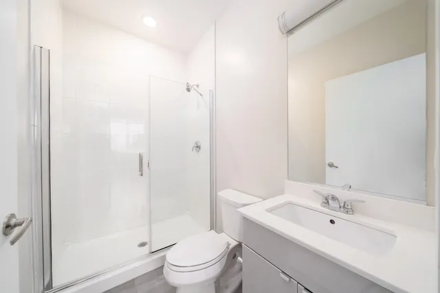 a bathroom with a toilet a sink a mirror and vanity