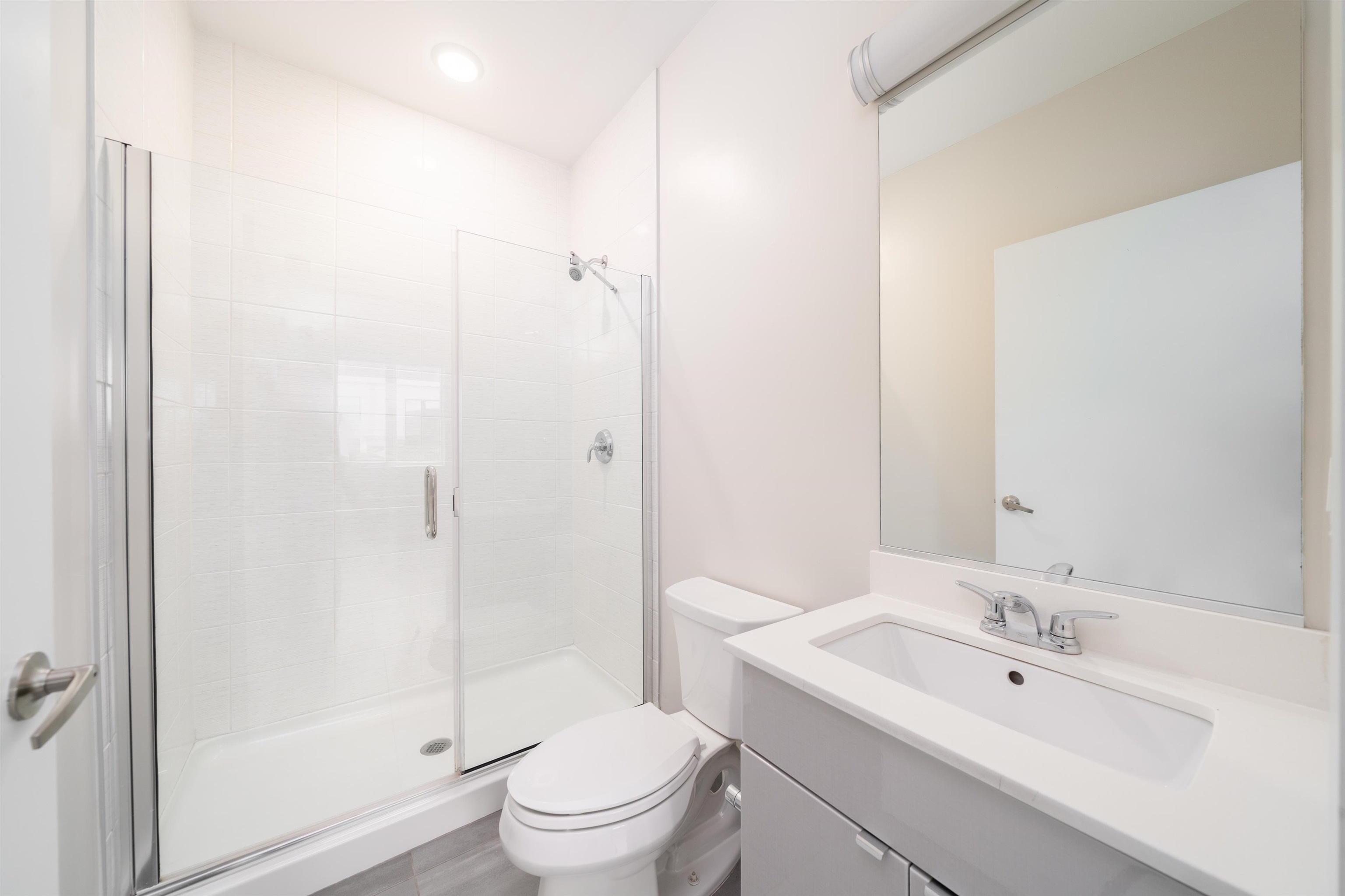 16 Bennett Street, Unit 211 Jersey City, NJ 07304 - Photo 15 of 24 a bathroom with a toilet a sink a mirror and vanity