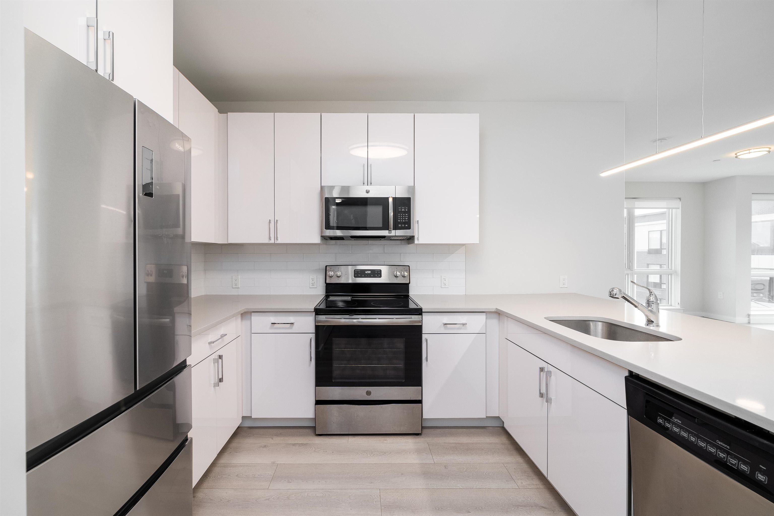 16 Bennett Street, Unit 211 Jersey City, NJ 07304 - Photo 2 of 24 a kitchen with a sink stove and refrigerator