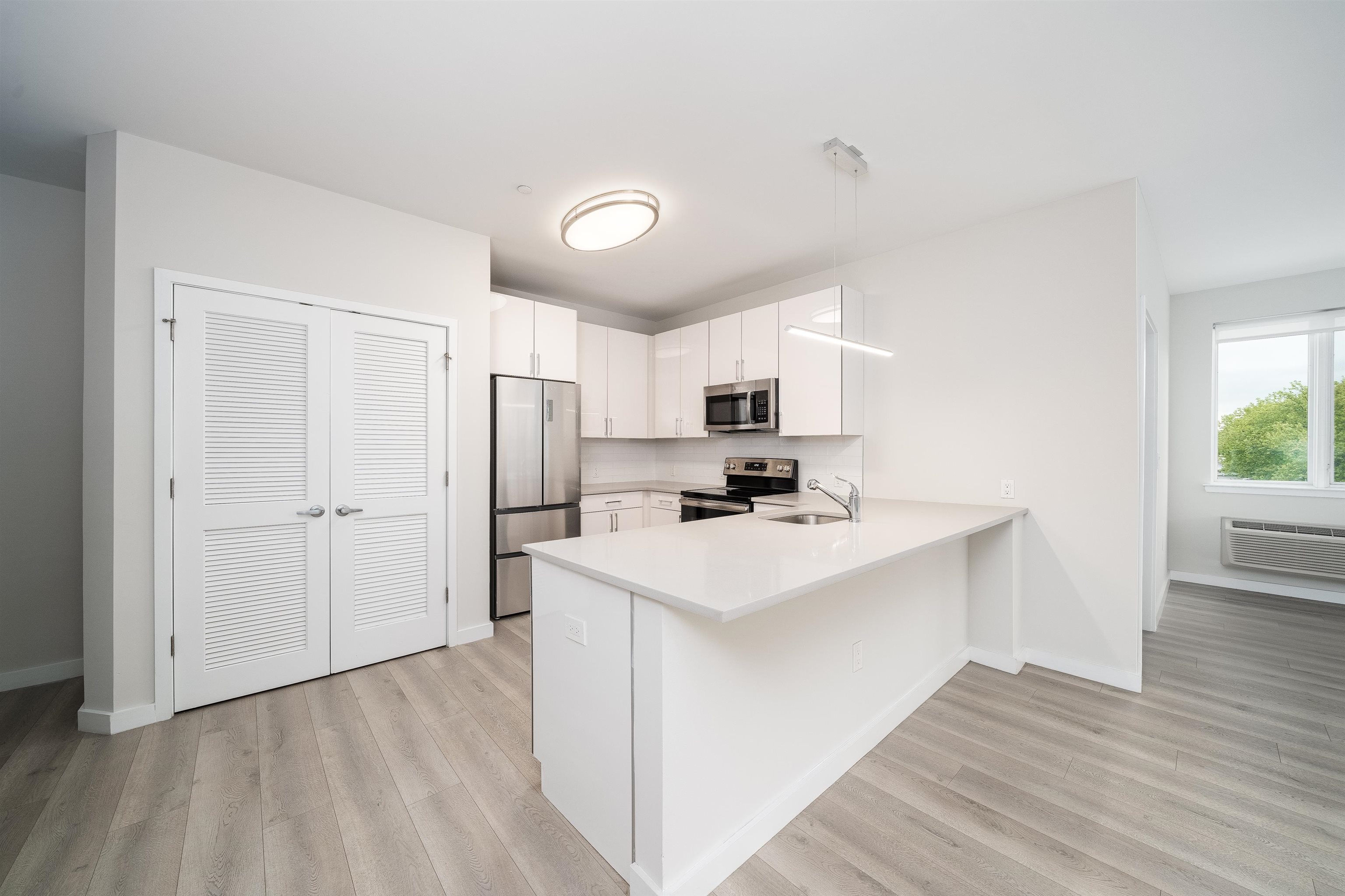 16 Bennett Street, Unit 211 Jersey City, NJ 07304 - Photo 3 of 24 a kitchen with refrigerator cabinets and wooden floor