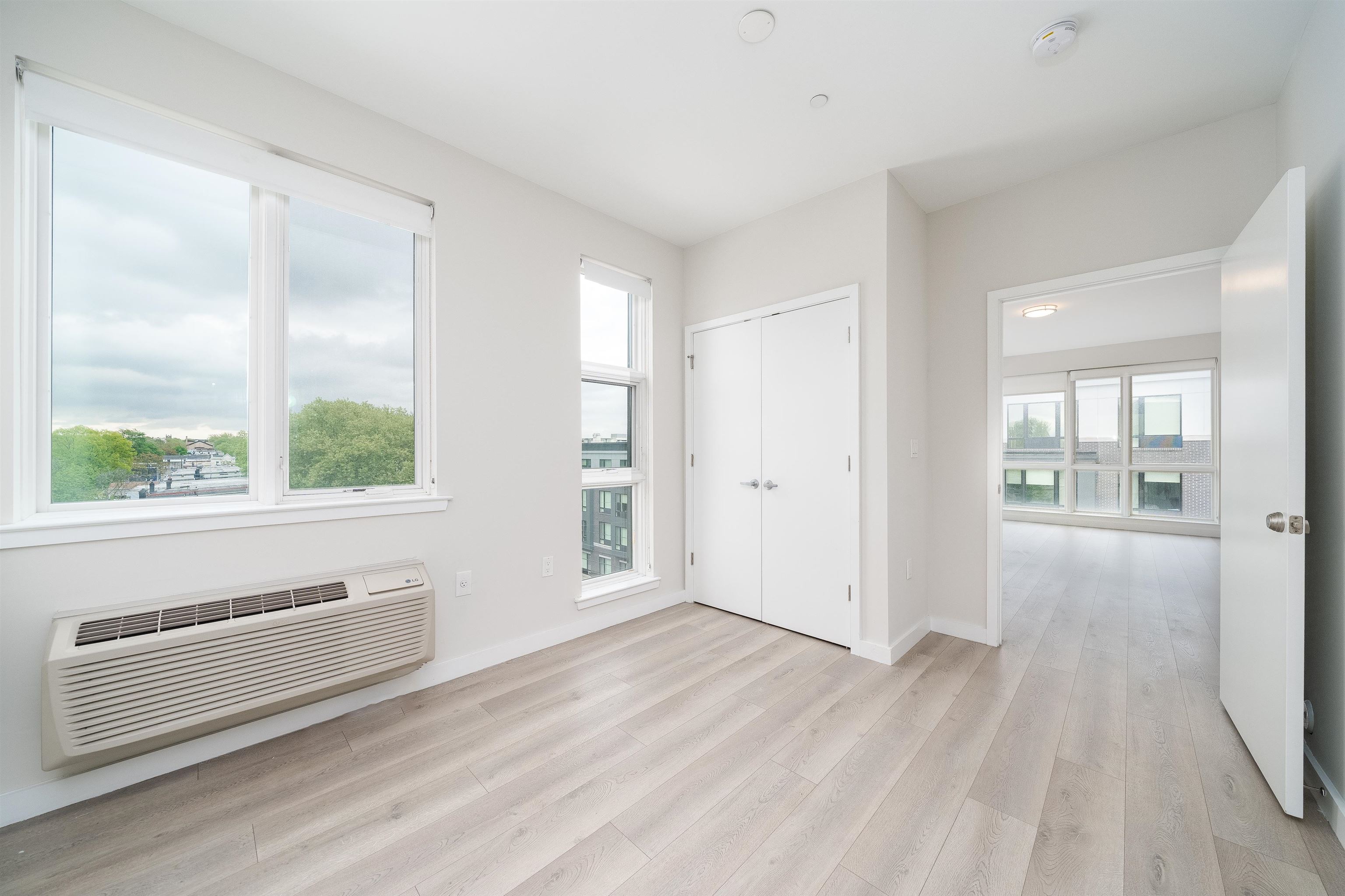 16 Bennett Street, Unit 211 Jersey City, NJ 07304 - Photo 4 of 24 a view of a livingroom with wooden floor and windows