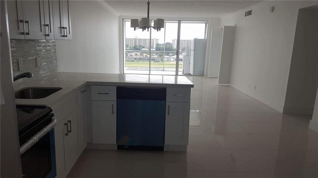 3150 North Course Lane, Unit 607 Pompano Beach, FL 33069 - Photo 7 of 16 a kitchen with a sink and cabinets