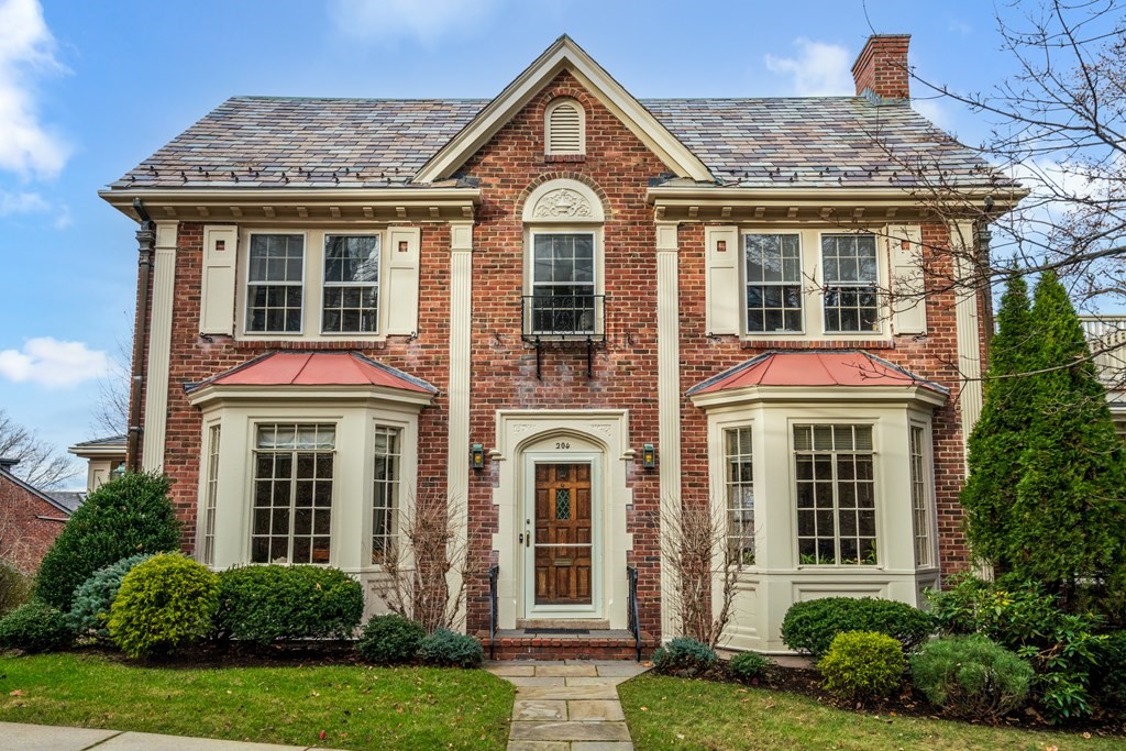 a front view of a house with yard and green space