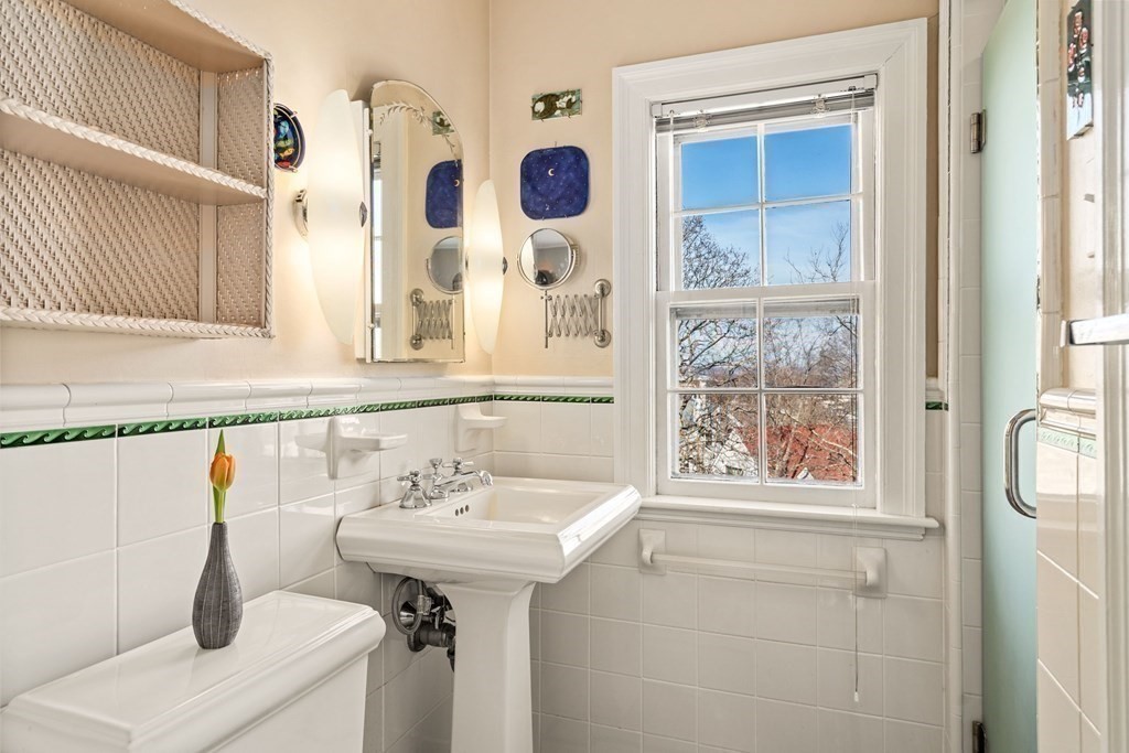 204 Lancaster Terrace Brookline, MA 02446 - Photo 16 of 32 a bathroom with a sink and mirror with window