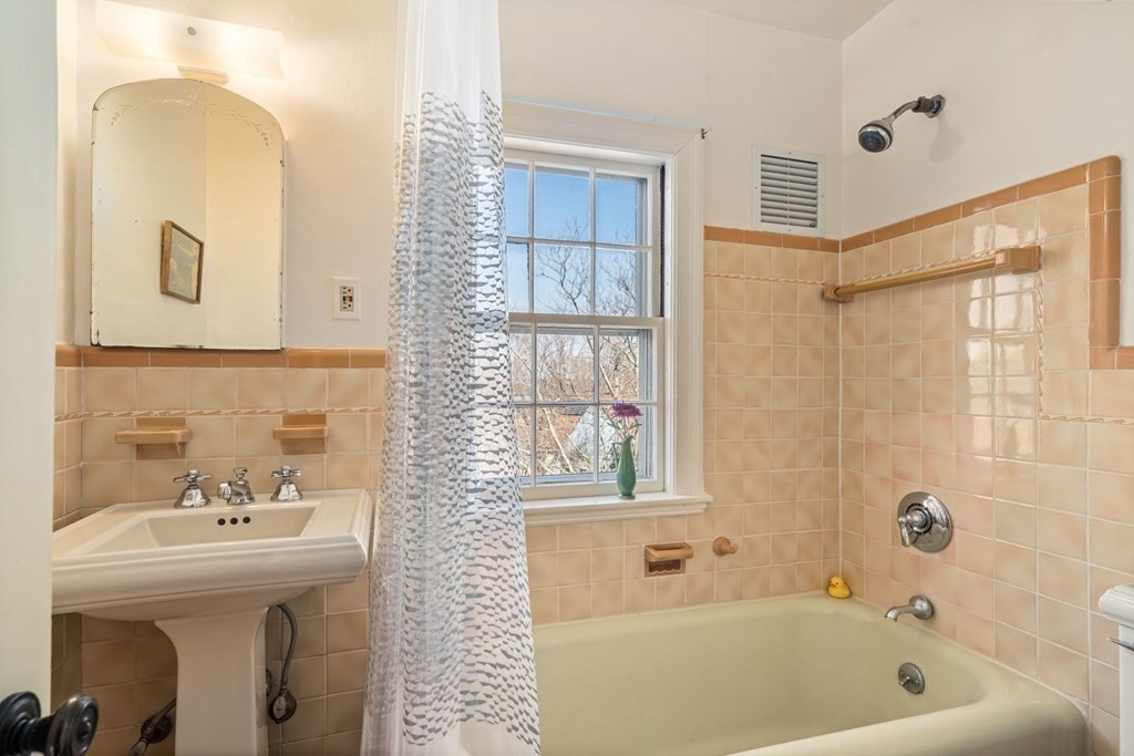 204 Lancaster Terrace Brookline, MA 02446 - Photo 21 of 32 a bathroom with a sink a mirror and a bathtub
