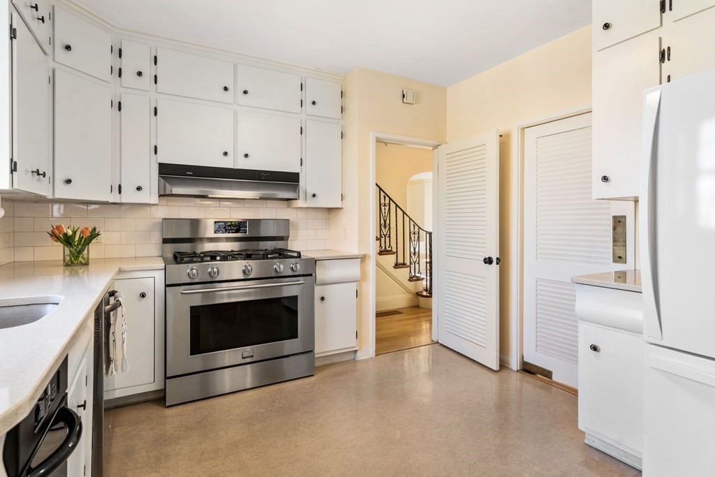 204 Lancaster Terrace Brookline, MA 02446 - Photo 4 of 32 a kitchen with stainless steel appliances white cabinets and a refrigerator