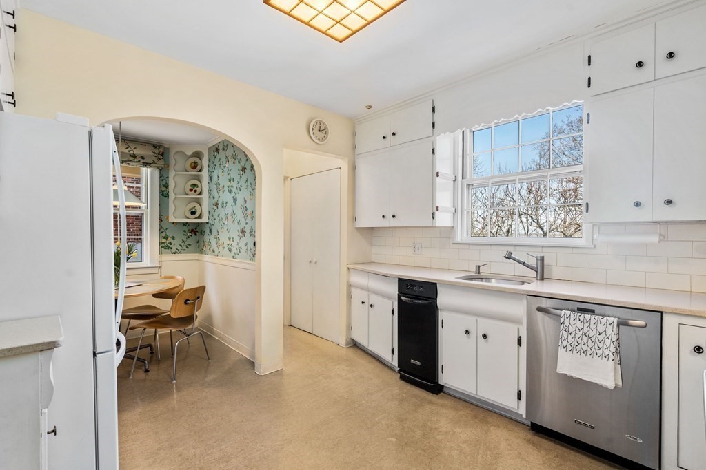 204 Lancaster Terrace Brookline, MA 02446 - Photo 6 of 32 a kitchen with granite countertop a sink cabinets and window