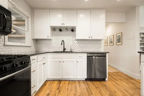 a kitchen with stainless steel appliances granite countertop a sink a stove and cabinets