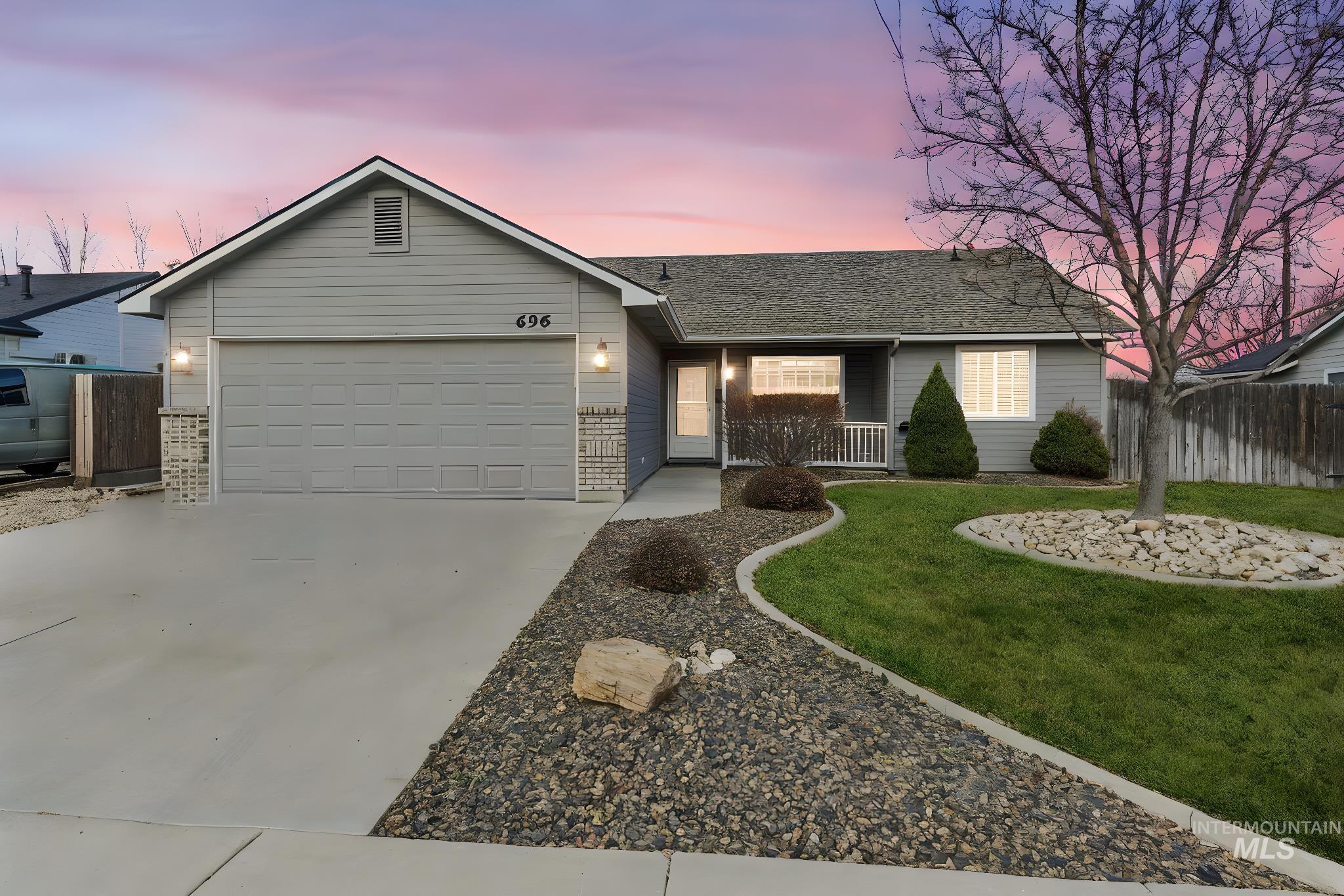 Ranch-style home featuring concrete driveway, a garage, roof with shingles, brick siding, and covered porch