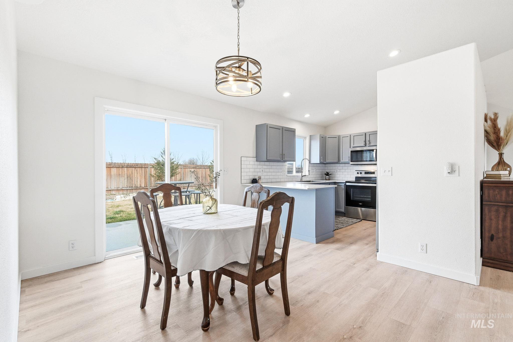 696 West Rams Hill Street Kuna, ID 83634 - Photo 11 of 46 Dining room with vaulted ceiling, light wood-type flooring, and recessed lighting