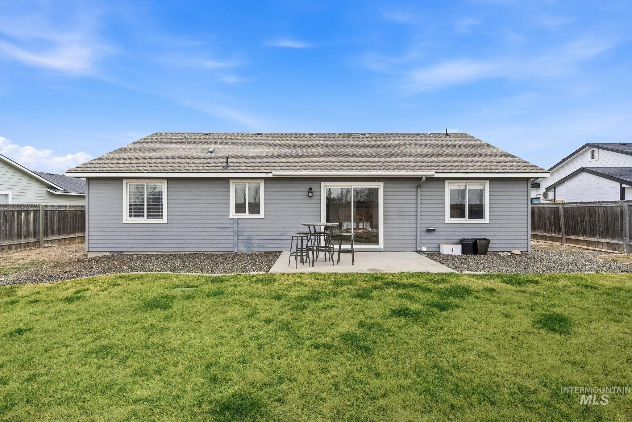 696 West Rams Hill Street Kuna, ID 83634 - Photo 38 of 46 Rear view of property with roof with shingles, a patio, and a fenced backyard