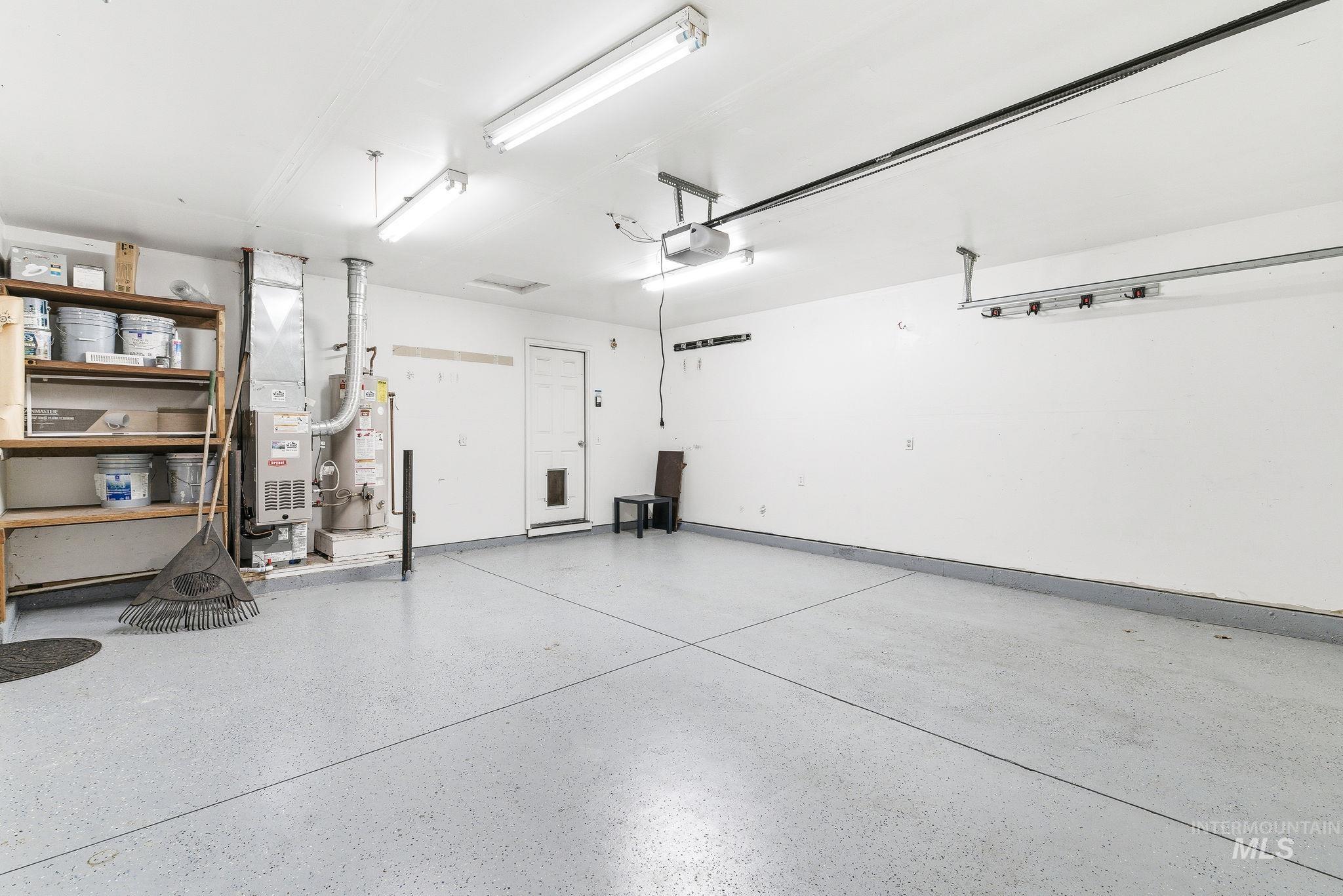 696 West Rams Hill Street Kuna, ID 83634 - Photo 46 of 46 Garage featuring heating unit, gas water heater, and a garage door opener