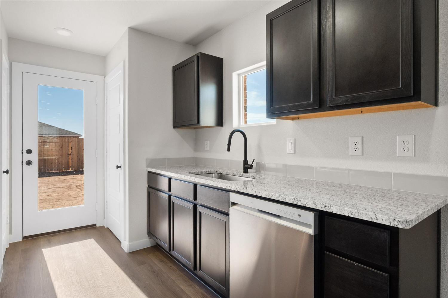 5519 Queens Street Lubbock, TX 79416 - Photo 12 of 21 a kitchen with stainless steel appliances granite countertop a sink and dishwasher with wooden cabinets