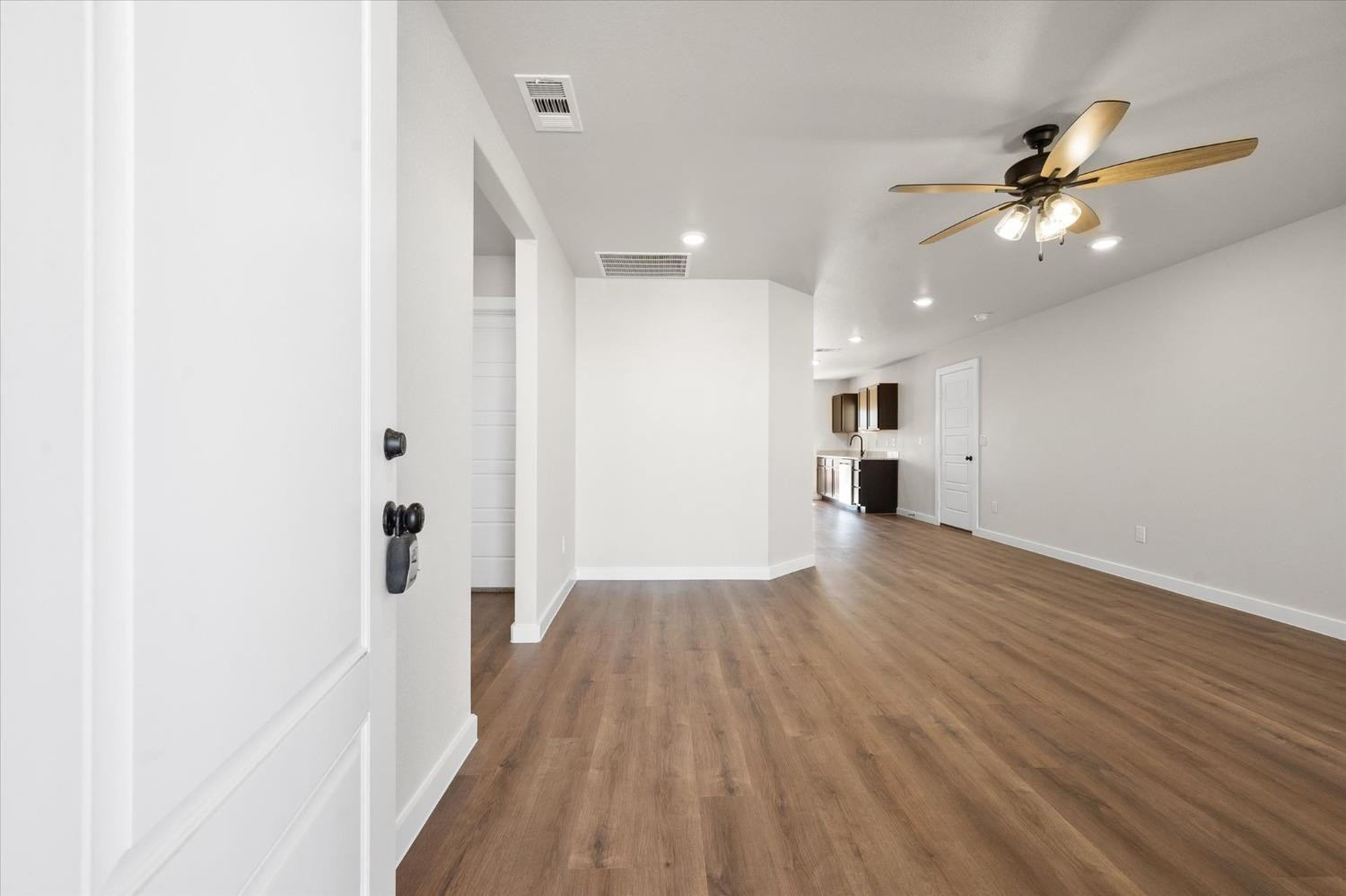 5519 Queens Street Lubbock, TX 79416 - Photo 3 of 21 a view of a hallway with wooden floor and a ceiling fan