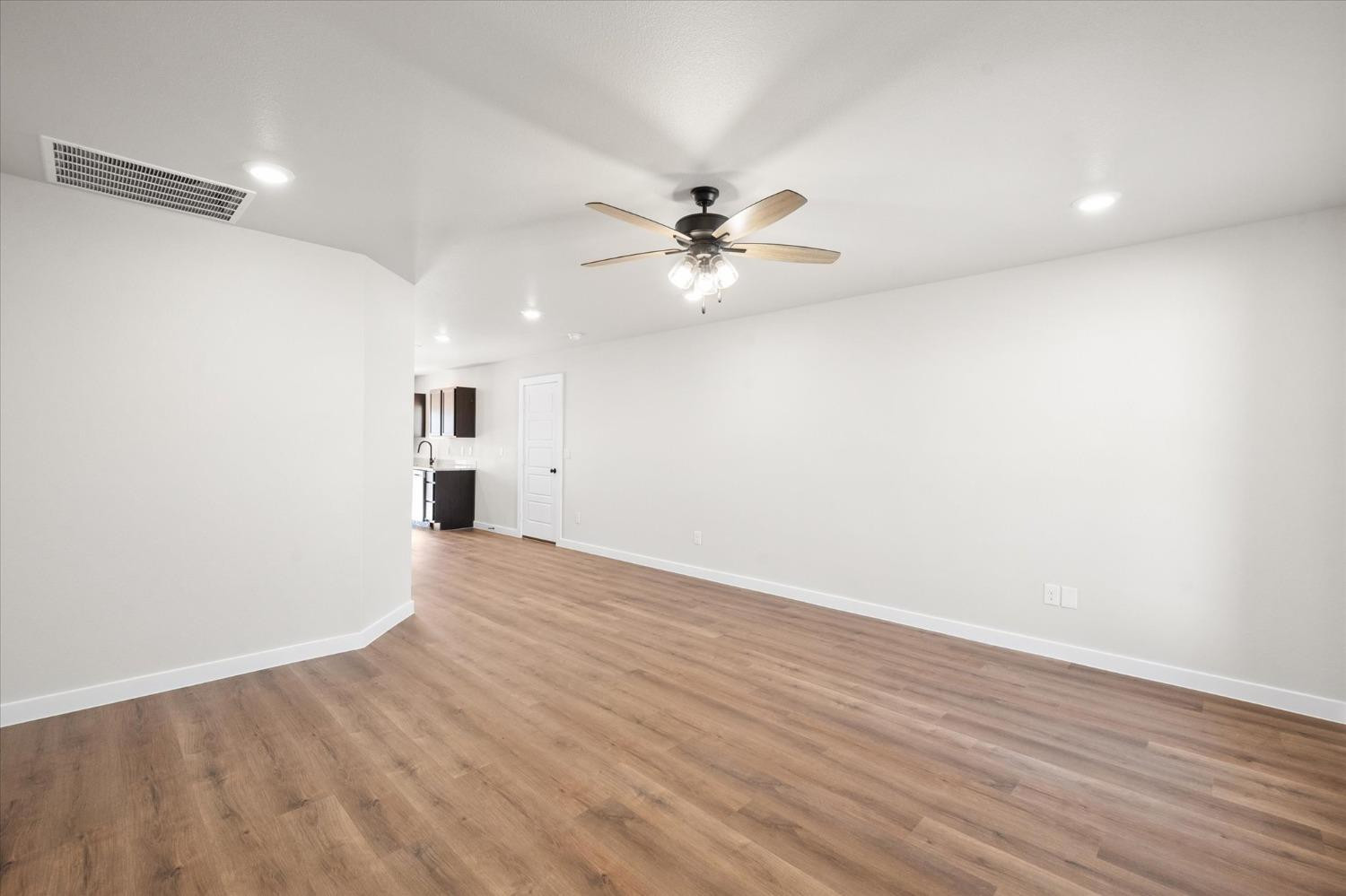 5519 Queens Street Lubbock, TX 79416 - Photo 4 of 21 an empty room with wooden floor and ceiling fan