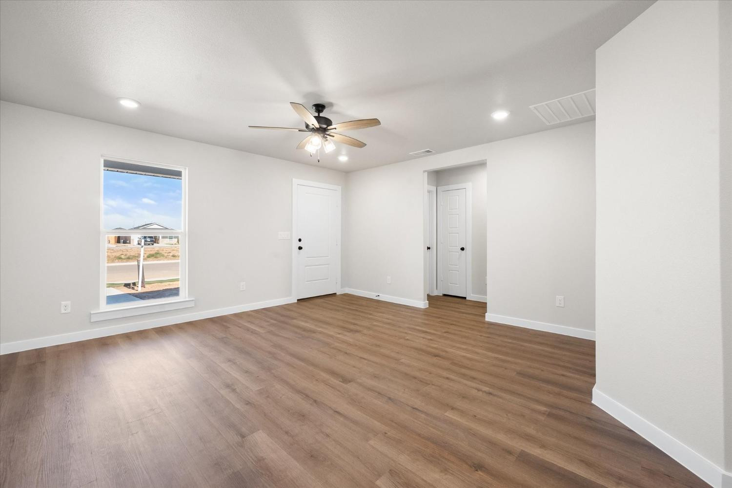 5519 Queens Street Lubbock, TX 79416 - Photo 6 of 21 an empty room with wooden floor and windows